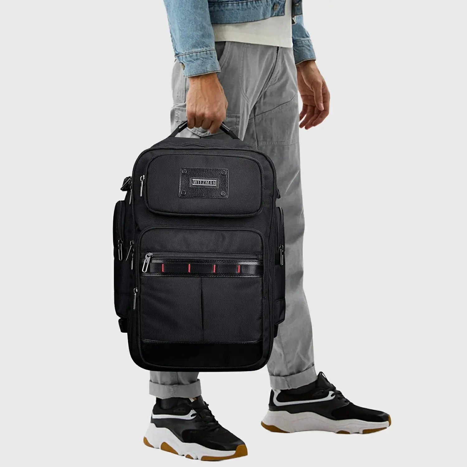 Man wearing WITZMAN black travel backpack for business, leisure and weekend travel