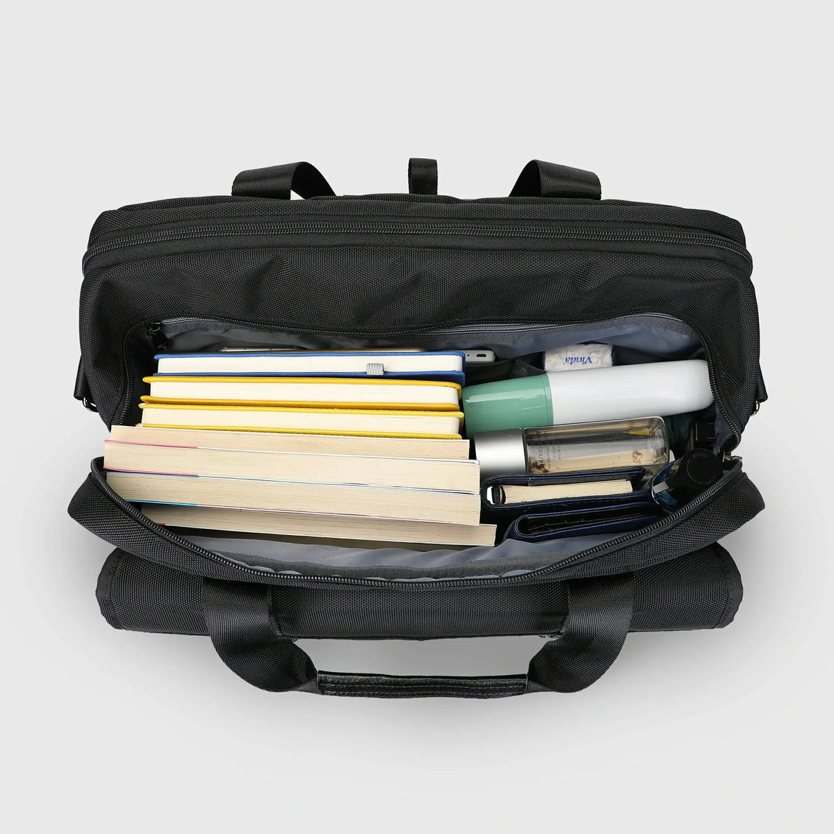 Open WITZMAN B769 laptop messenger bag showing the large main compartment packed with books, notebooks, headphones and travel essentials.