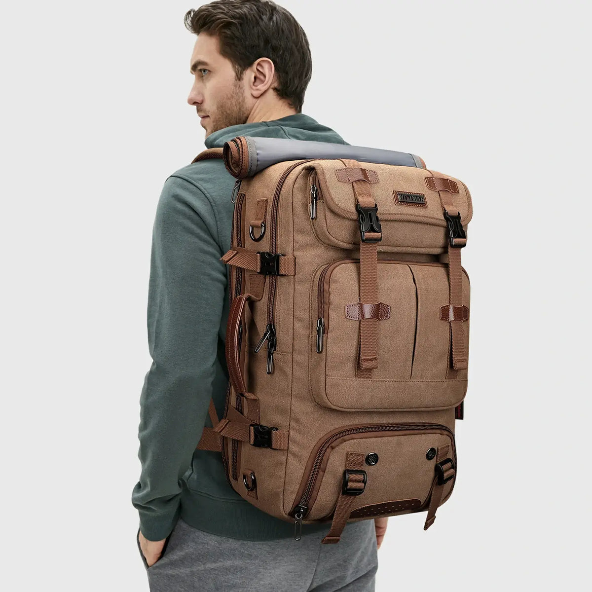 Man wearing WITZMAN brown canvas travel backpack for weekend and international travel