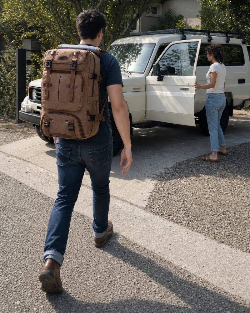 Traveler wearing a full-size brown WITZMAN A8013 40L backpack while walking toward a parked vehicle