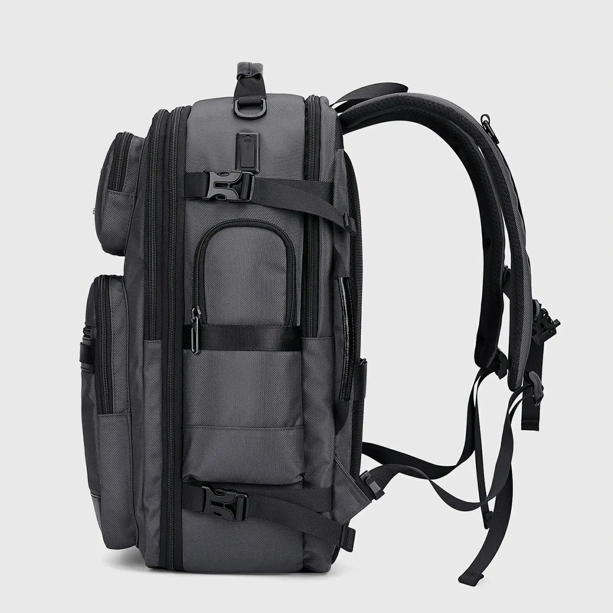 Side view of silver grey nylon travel backpack with padded straps and dual USB ports