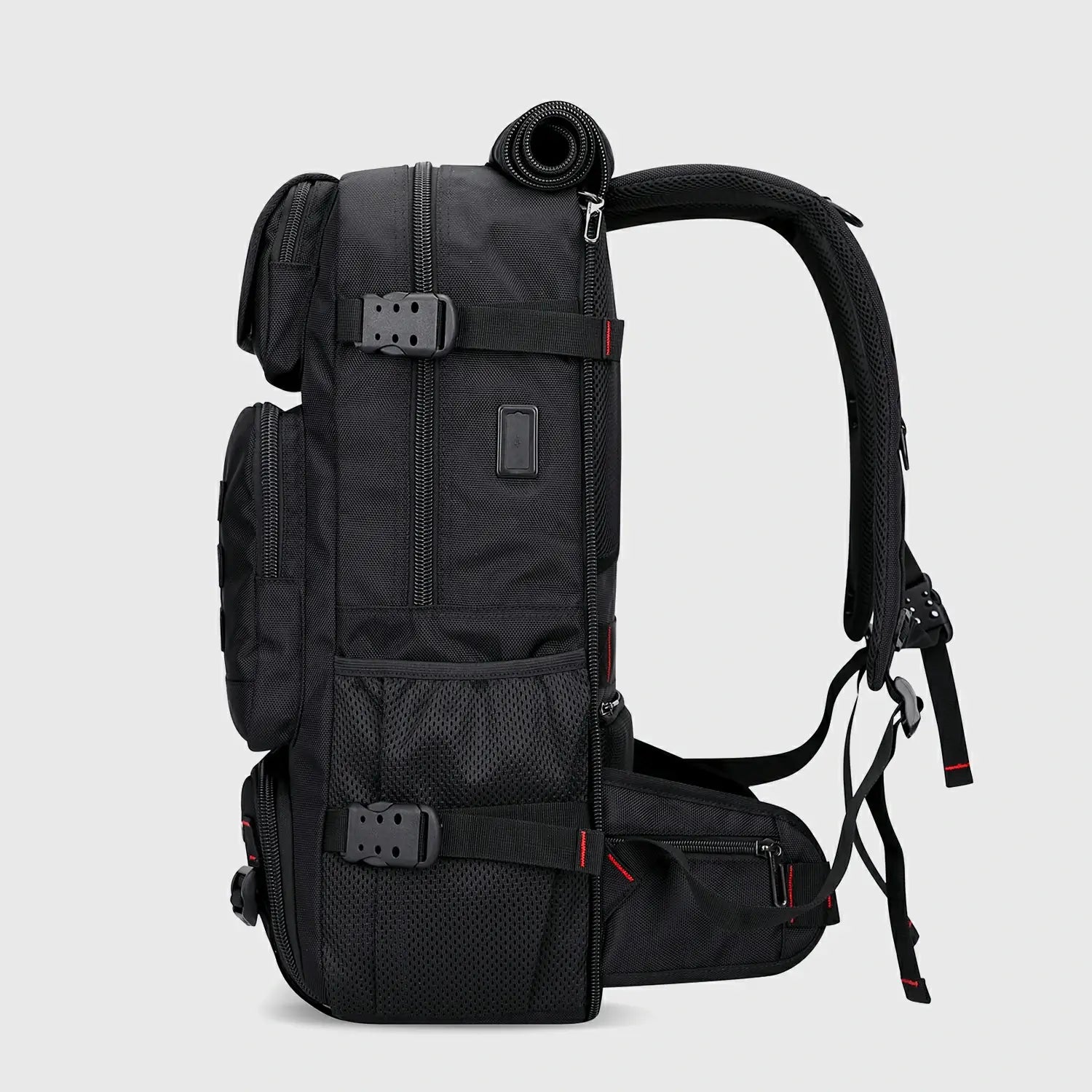 Side view of black nylon travel backpack with USB charging port and compression straps