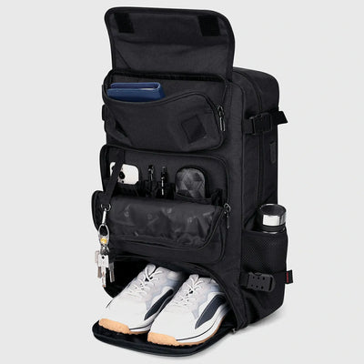 Black travel backpack with separate shoe compartment and front organizer pockets open