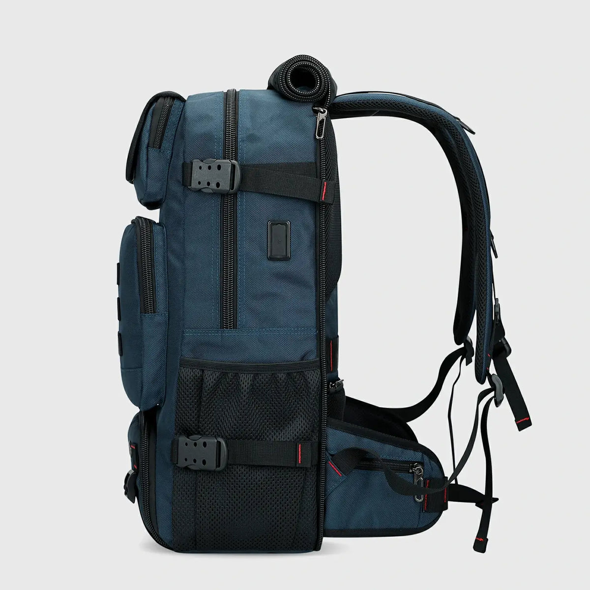 Side view of blue nylon travel backpack with USB charging port and compression straps