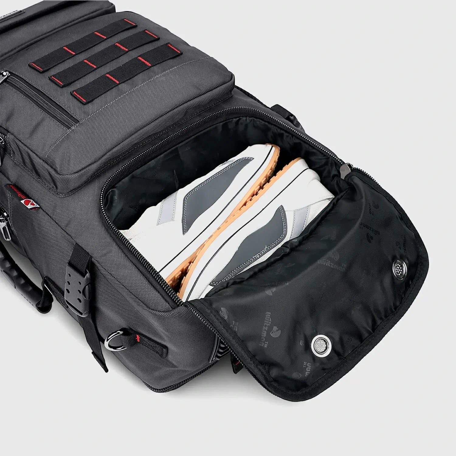 Close-up of separate shoe compartment in silvery grey nylon travel backpack