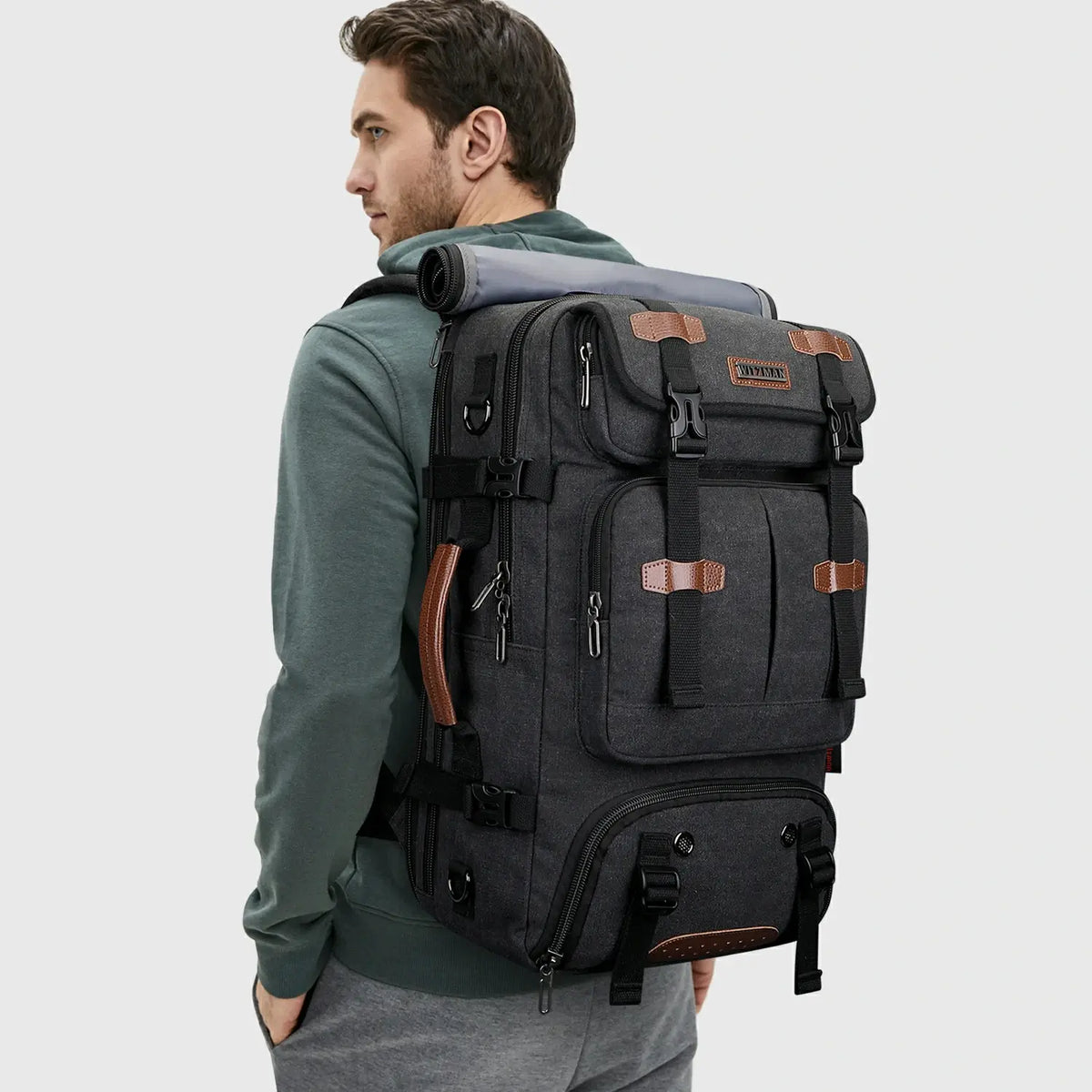 Man wearing WITZMAN black canvas travel backpack for weekend and business travel