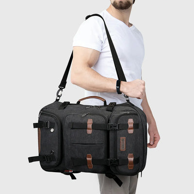 Black convertible canvas travel backpack carried as a crossbody shoulder bag by a male traveler