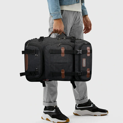 Black 3-in-1 canvas travel backpack carried by the side handle in duffel bag mode
