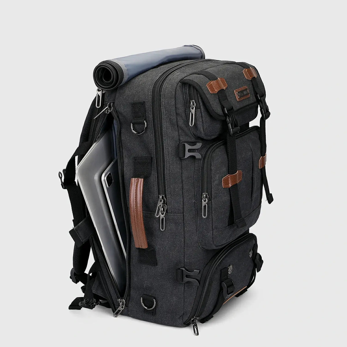 Three-quarter view of black canvas travel backpack for men with multiple zippered compartments