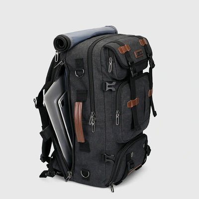 Three-quarter view of black canvas travel backpack for men with multiple zippered compartments