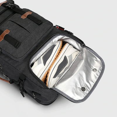 Close-up of ventilated shoe compartment inside black canvas travel backpack for men