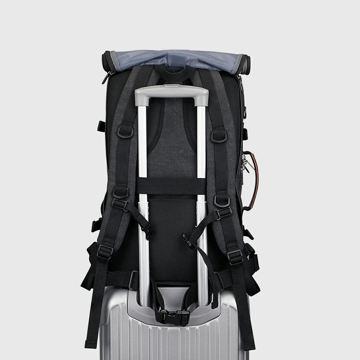 Black 3-in-1 travel backpack with shoulder straps stored behind the roll-top back panel