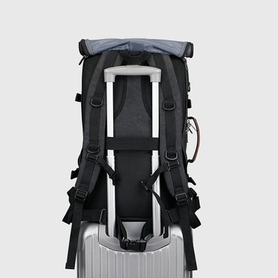 Black 3-in-1 travel backpack with shoulder straps stored behind the roll-top back panel