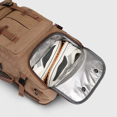 Close-up of ventilated shoe compartment inside brown canvas travel backpack for men