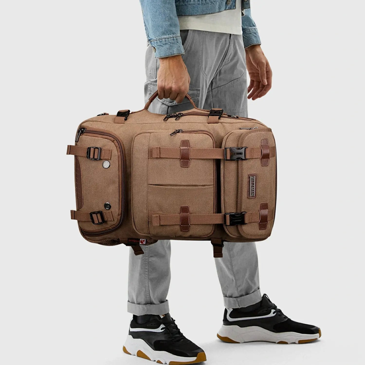 Brown 3-in-1 canvas travel backpack carried by the side handle in duffel bag mode