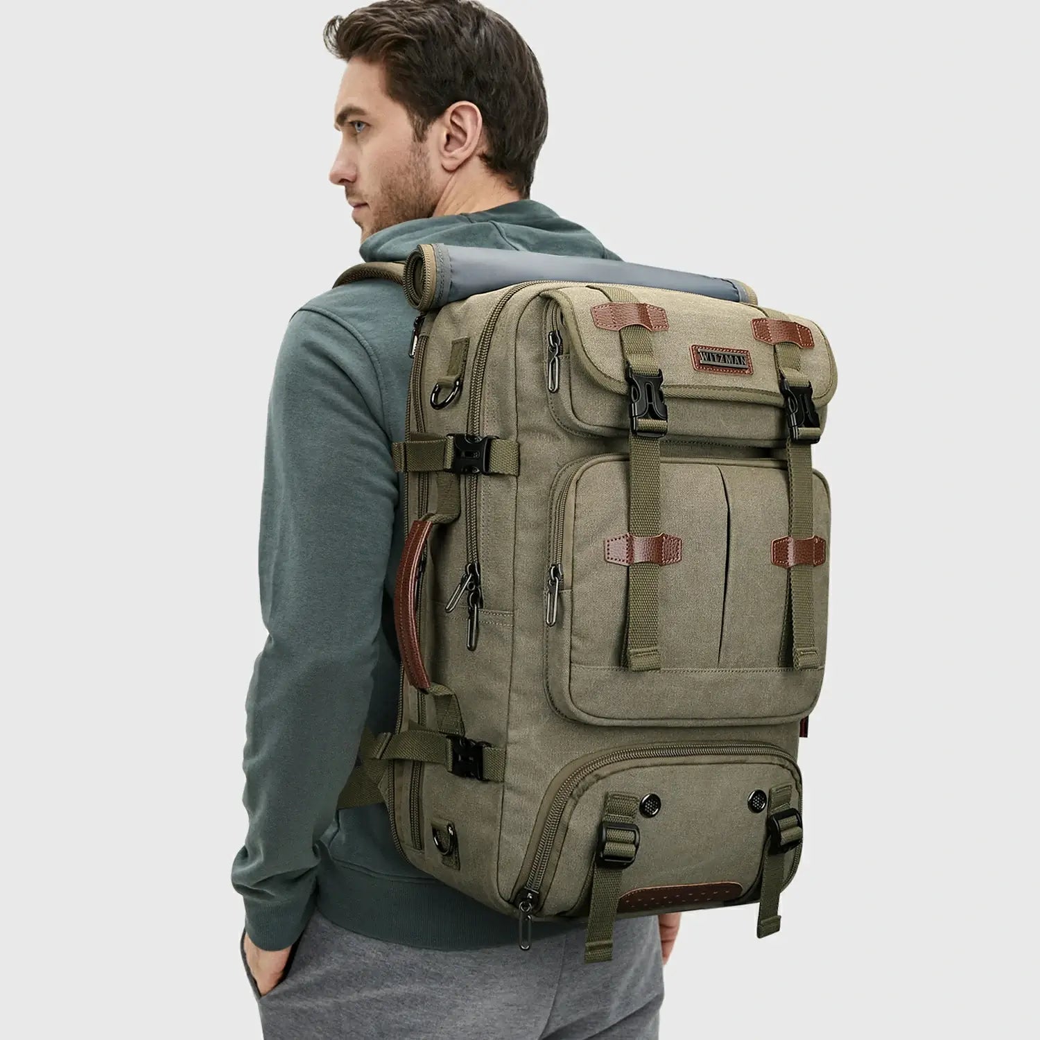 Man wearing WITZMAN army green canvas travel backpack for outdoor and weekend travel