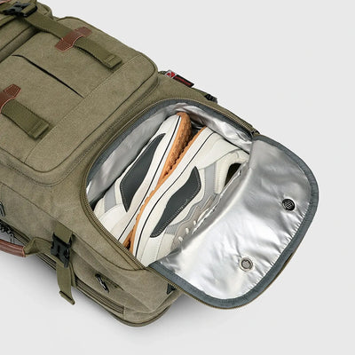 Close-up of ventilated shoe compartment inside army green canvas travel backpack for men