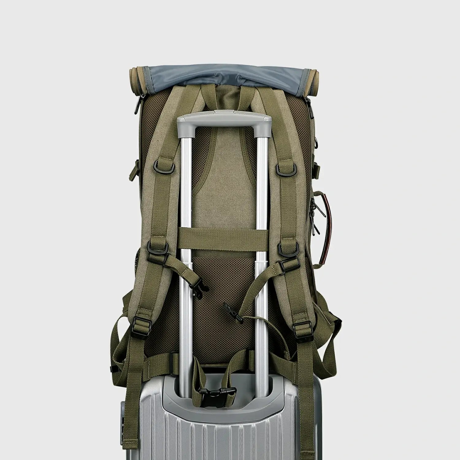 Army green 3-in-1 backpack with shoulder straps stored behind the roll-top back panel